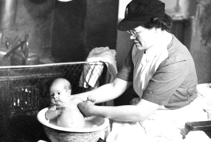 A district midwife bathing a baby back in the 1960s